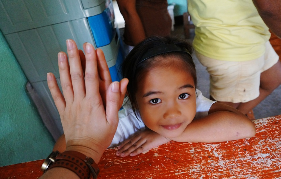 Volunteer giving a girl a high five