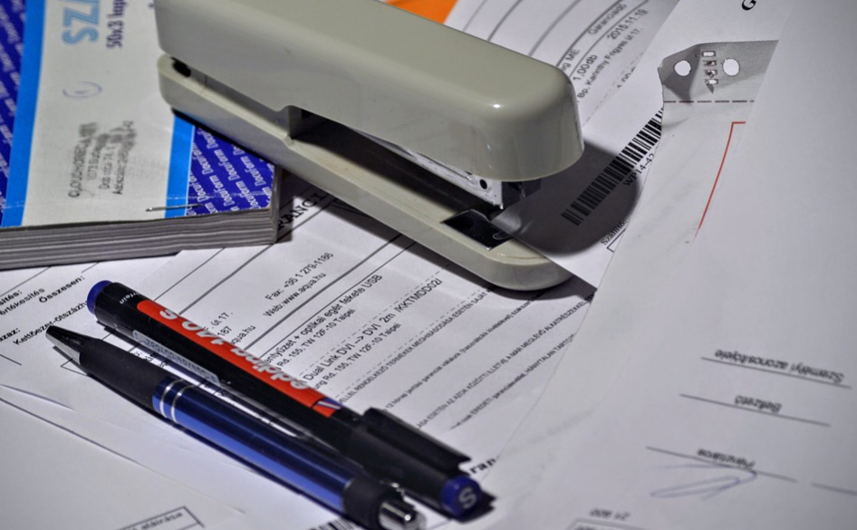 A stapler and pens over paperwork
